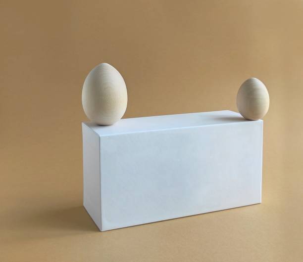 istock Wooden easter eggs for painting on white box podium on a pastel background. Scene with geometrical forms. Copy space. 1275801946