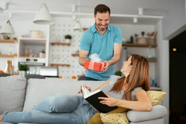 istock Husband surprising his wife with a gift. 1275802074