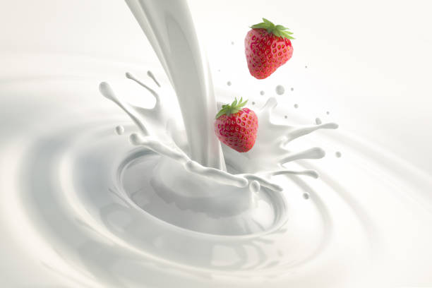 Milk splash Two Strawberries splashing into pouring milk on white background splash crown stock pictures, royalty-free photos & images