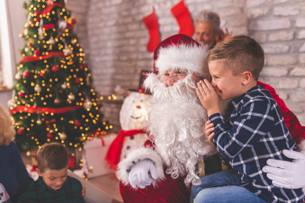 niño sentado en santas vuelta susurrando deseos para regalos de navidad - whispering grandparent child grandfather fotografías e imágenes de stock