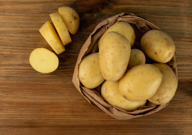 istock Raw Chopped Potato on Wooden Cutting Board Background 1275804956