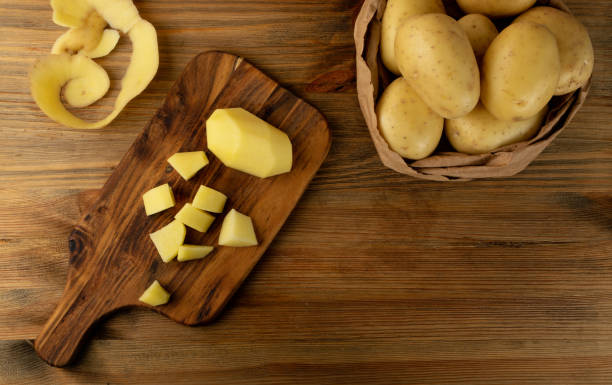 istock Raw Chopped Potato on Wooden Cutting Board Background 1275804961