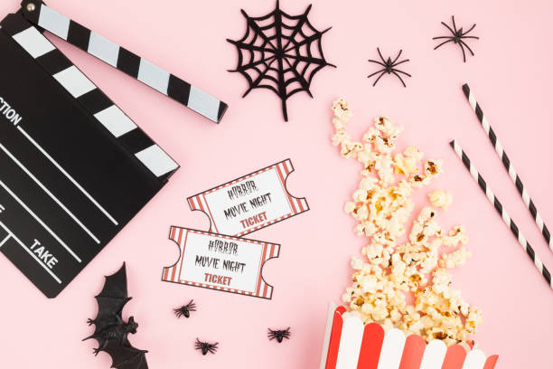 istock Movie clapperboard and halloween decoration over pink background 1275807044