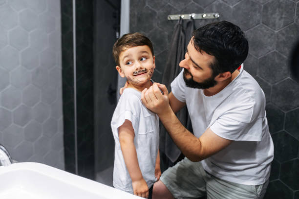 istock Dad is drawing beard on face of little son 1275811343