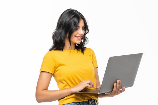 istock Young smiling confident woman using laptop and looking camera isolated over white 1275811506