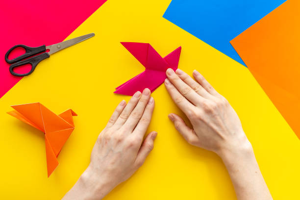 istock DIY concept. Doing origami paper bird, Top view 1275812544