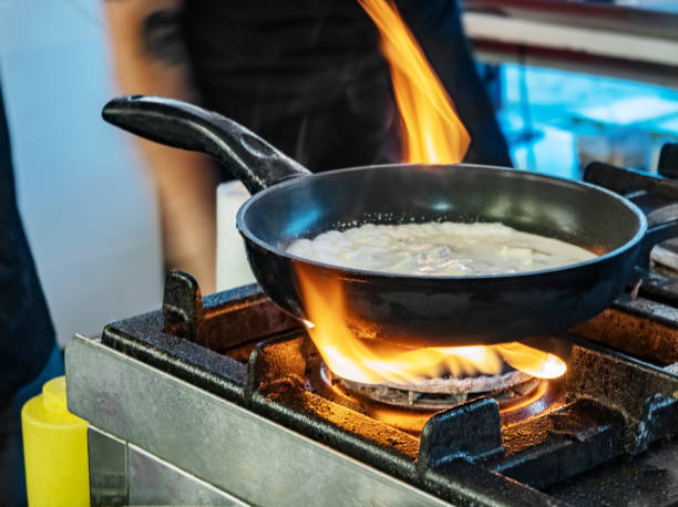 istock Chef cooking noodles and vegetables in a pan on fire 1275812646
