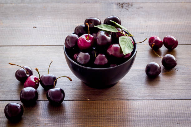 istock Red cherries with leaves in the bowl. Berries background 1275812892