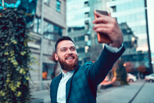 istock Smiling Elegant Male Taking Selfie Outside 1275815533
