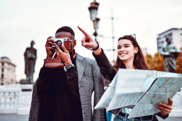istock Mixed Couple Walking Through City With Map And Photographing 1275817617