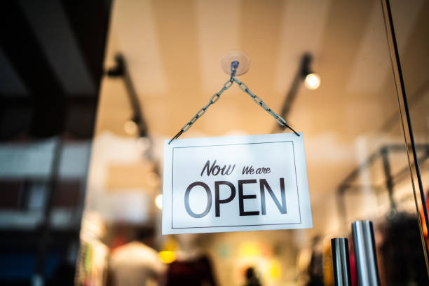 istock Opened sign seen through glass door at store 1275819088