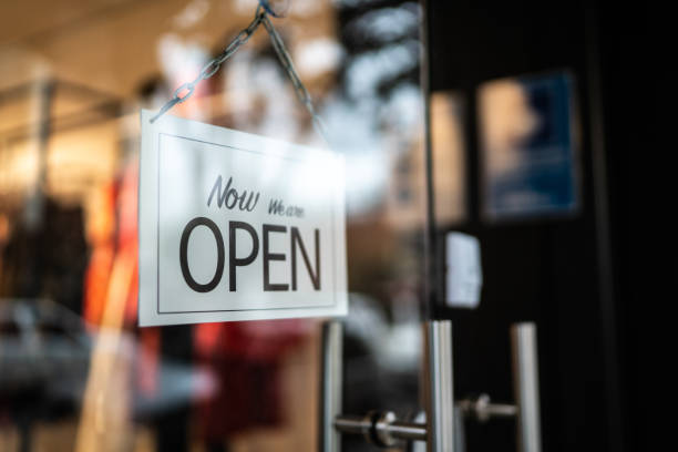 istock Opened sign seen through glass door at store 1275819404