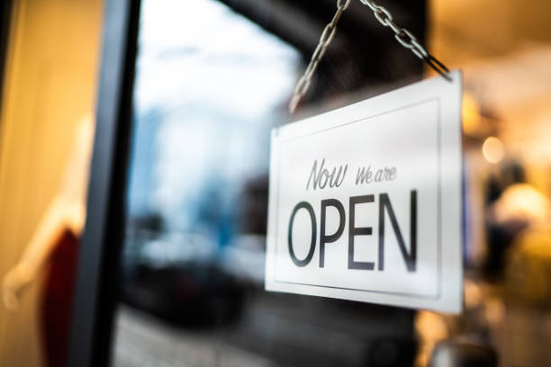istock Opened sign seen through glass door at store 1275819614