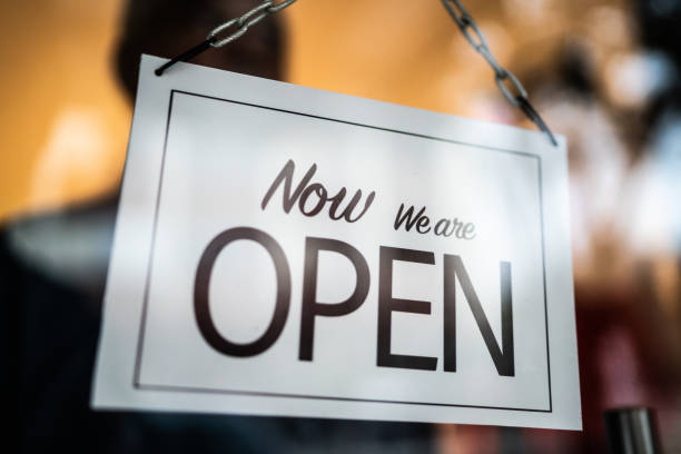 istock Opened sign seen through glass door at store 1275820447