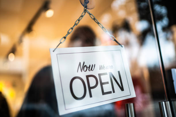 istock Opened sign seen through glass door at store 1275820504
