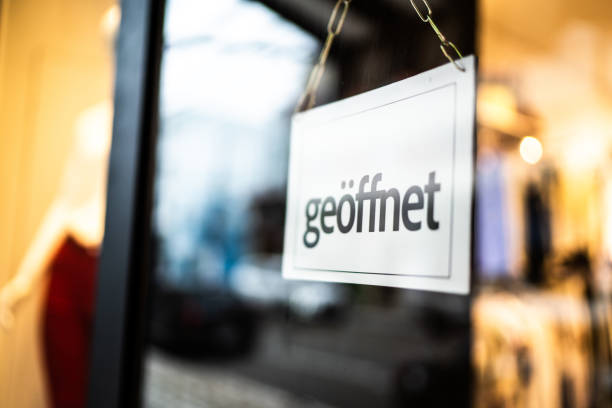 istock Opened sign (geöffnet) seen through glass door at store 1275820841
