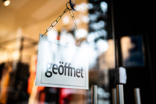 istock Opened sign (geöffnet) seen through glass door at store 1275821835