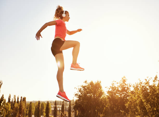 istock Fit woman jumping against blue sky 1275822212
