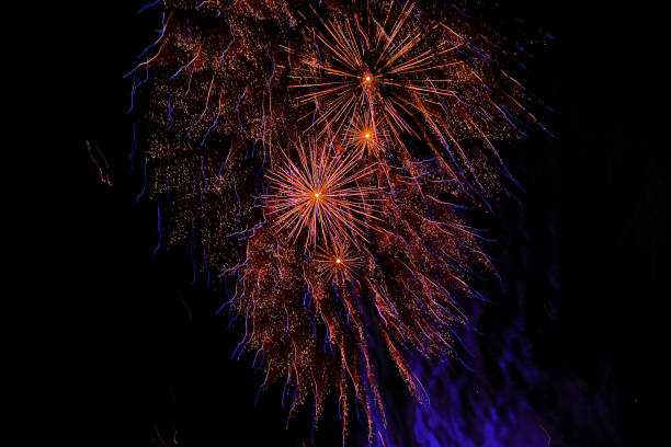 istock Orange and blue fireworks in the night sky 1275822777
