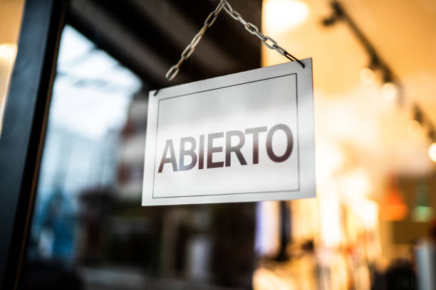istock Opened sign (abierto) seen through glass door at store 1275823498