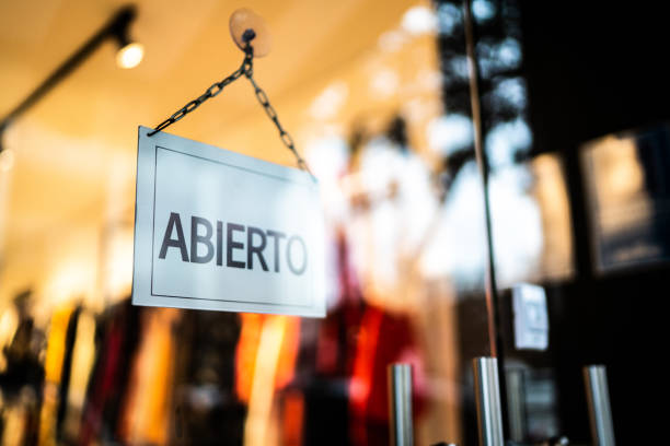 opened sign (abierto) seen through glass door at store - window display commercial sign blank nobody imagens e fotografias de stock