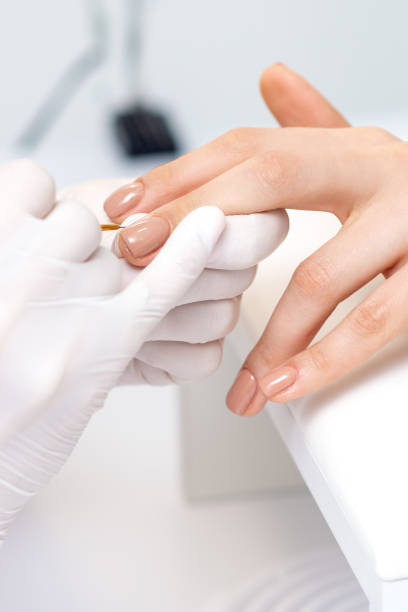 istock Manicure master applying beige nail polish 1275823555