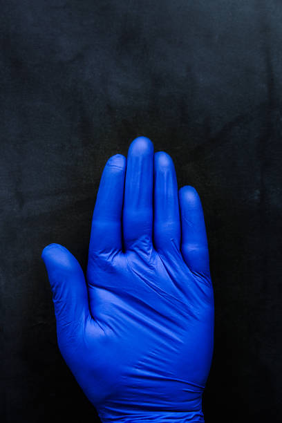Hand with medical gloves on a dark background
