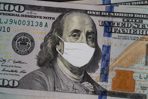istock Stack of USA dollars banknotes with protective mask on it 1275827879