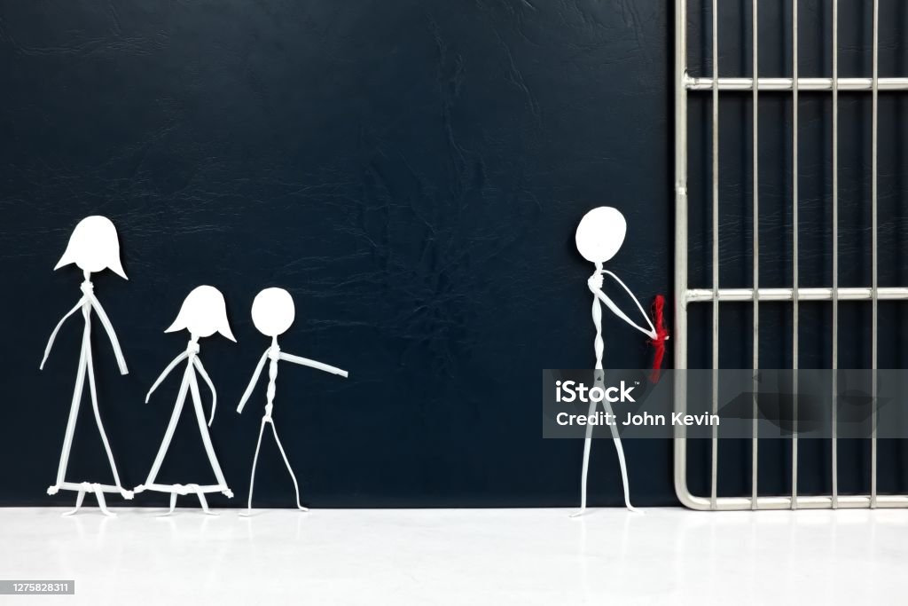 Stick figure father handcuffed tied with red rope going to a jail prison with sad family on the side in dark background. Husband guilty of crime, imprisonment, capture and broken family concept. Stick Figure Stock Photo