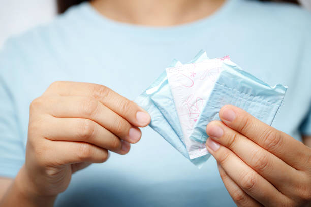 una mujer lleva una servilleta sanitaria, es menstrual - hygienic pad fotografías e imágenes de stock