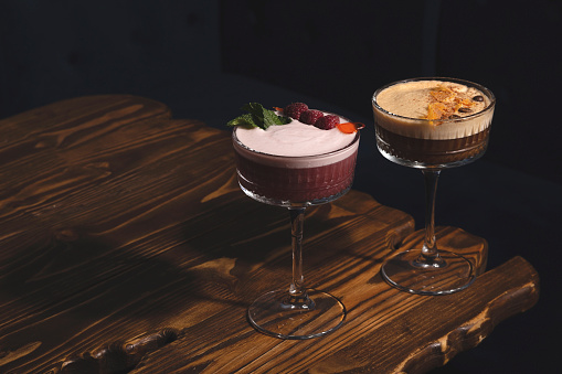 Sour trendy drinks with egg foam and filling. Raspberry mint and Coffee with spices cocktails in hard light