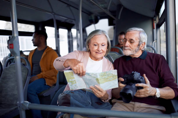 istock Senior couple looking together at map traveling inside bus 1275830729