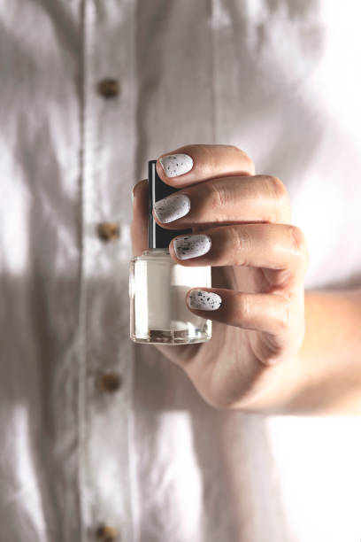istock White nail polish in a bottle and on a woman's manicure 1275830791