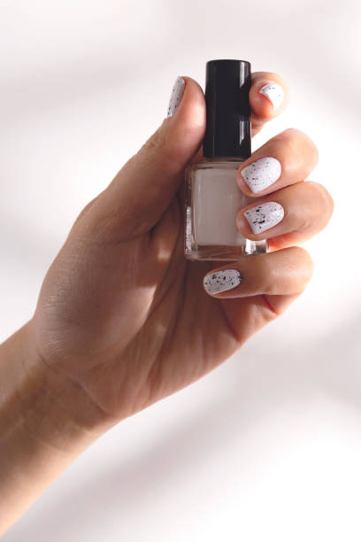 istock White nail polish in a bottle and on a woman's manicure 1275830797