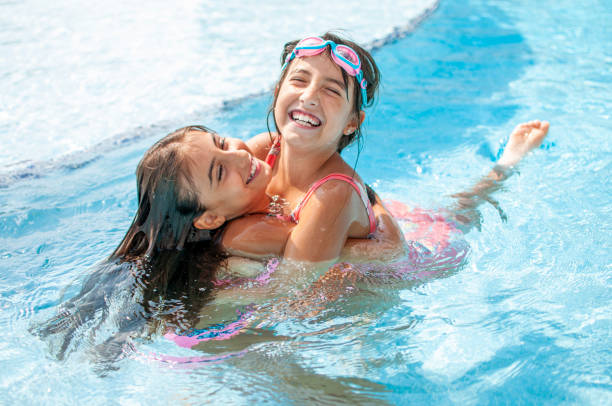 istock Happy child girls posing in the pool 1275831003