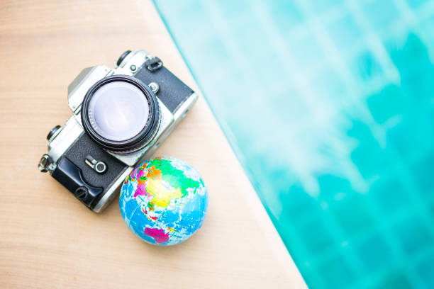 istock Old film camera with glabal ball on swimming pool edge 1275831090