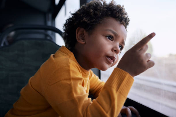 istock African-american boy pointing with finger out the window inside public bus 1275831897