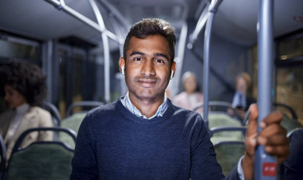 Indian business man smiling commuting to work on public bus
