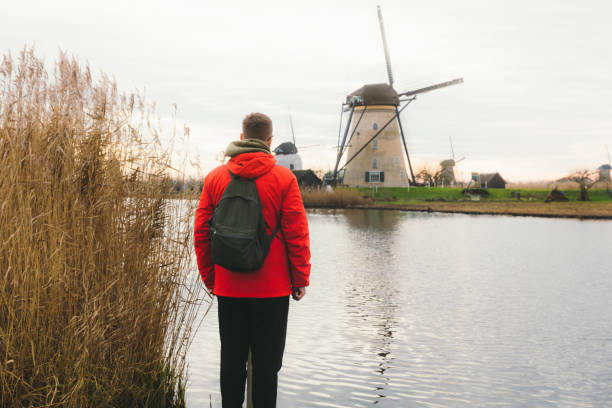 istock Young man tourist exploring the windmills in Kinderdijk in Netherlands 1275832646