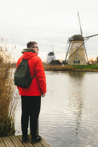 istock Young man tourist exploring the windmills in Kinderdijk in Netherlands 1275833209