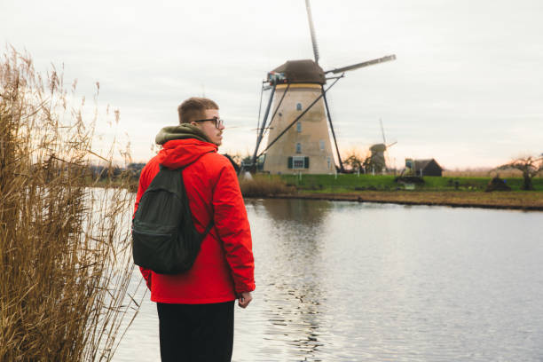 istock Young man tourist exploring the windmills in Kinderdijk in Netherlands 1275833238