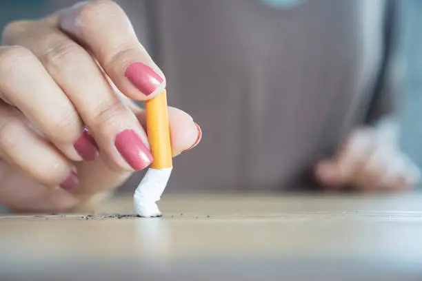 Photo of closeup woman hand destroying cigarette stop smoking concept