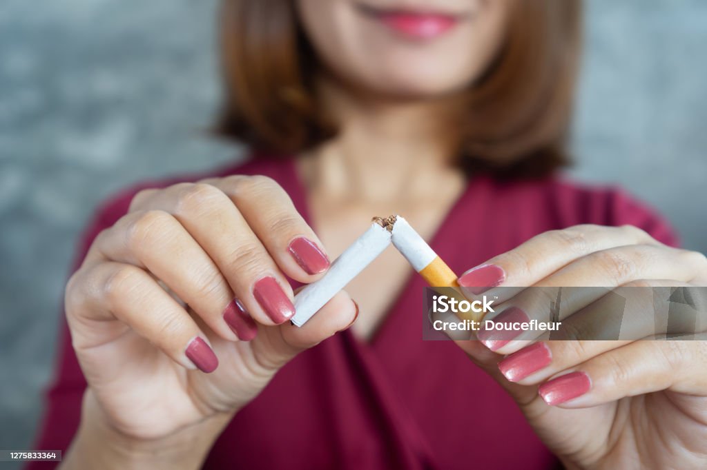 closeup woman hand breaking cigarette stop smoking concept Smoking Issues Stock Photo