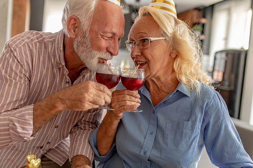 Close up of senior couple at home toasting