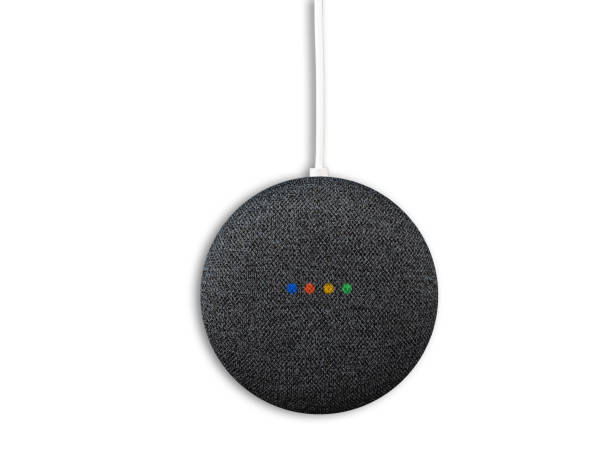 directly above view of charcoal colored google nest mini smart speaker 2020-09-23 Hamburg, Germany: directly above view of charcoal colored google nest mini smart speaker with illuminated status LEDs isolated on white google home stock pictures, royalty-free photos & images