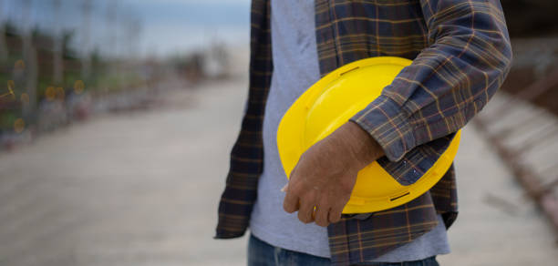 istock Construction worker holding safety helmet yellow on the construction site with copy space 1275838166