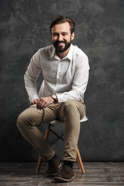 istock Cheerful bearded businessman sitting over grey wall 1275838304