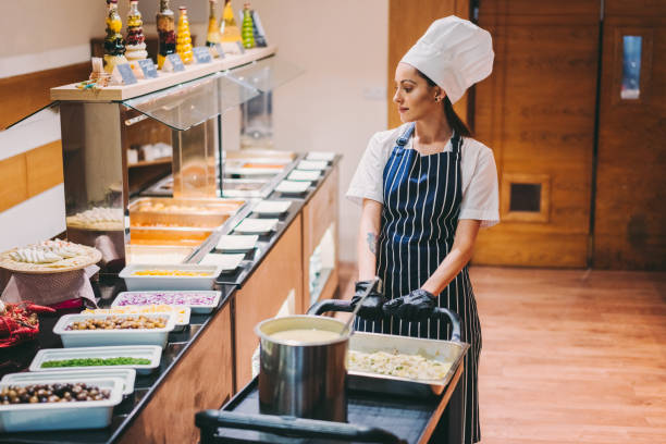 istock Chef in luxury hotel setting out cooked food in warming trays 1275841280
