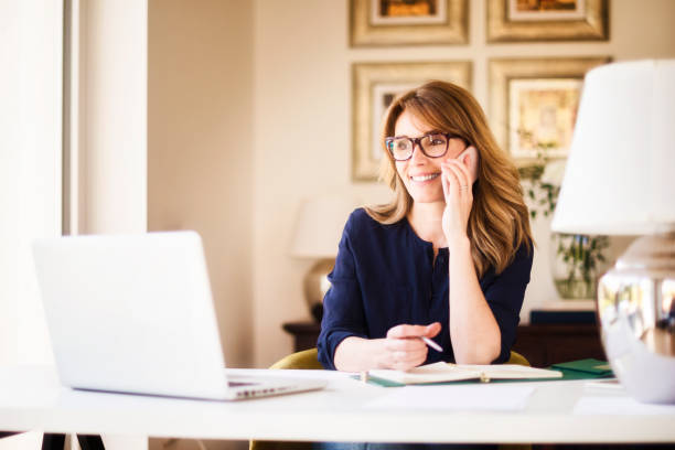 istock Attractive businesswoman working from home while using mobile phone and laptop 1275841619