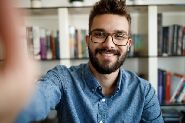 istock Smiling young man having online conference from home 1275841693